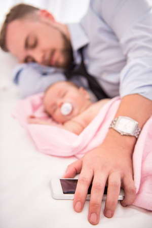 Portrait of young happy father with a baby at homeの写真素材