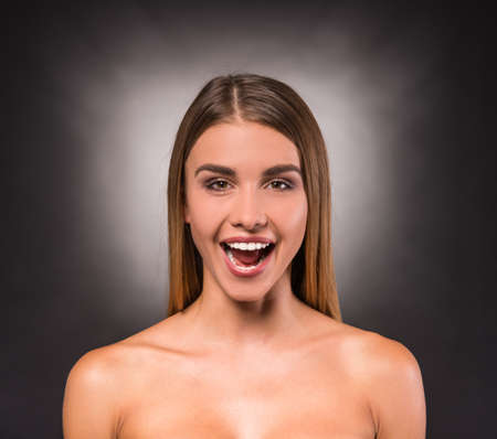 Portrait of a young, beautiful, emotional woman on a dark background. Studio shootの写真素材