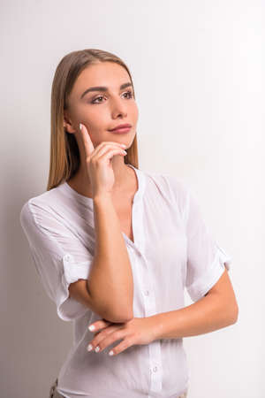Portrait of a young, beautiful, emotional woman on gray background. Studio shootの写真素材