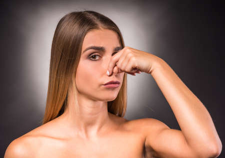Portrait of a young, beautiful, emotional woman on a dark background. Studio shootの写真素材