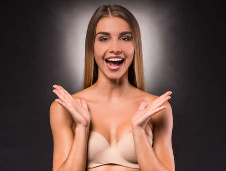 Portrait of a young, beautiful, emotional woman on a dark background. Studio shootの写真素材