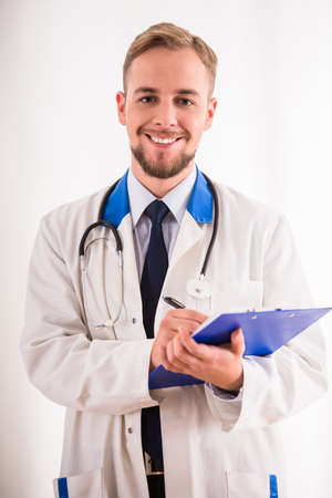 Portrait of tired young doctor in a white coat on a white backgroundの写真素材