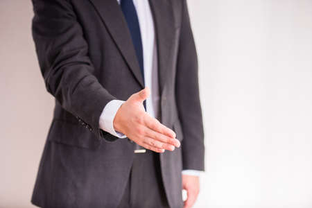 Handshake. Portrait of a young cheerful businessman holding hand for shakingの写真素材