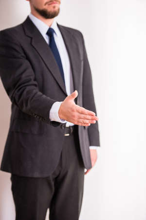 Handshake. Portrait of a young cheerful businessman holding hand for shakingの写真素材