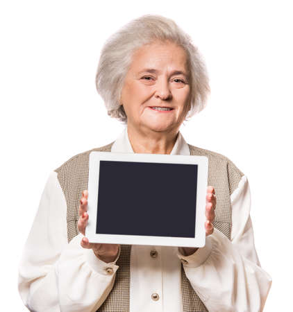 Senior woman using tablet isolated on white backgroundの写真素材