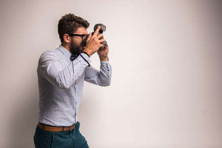 Young cheerful photographer with beard, while working in studioの写真素材