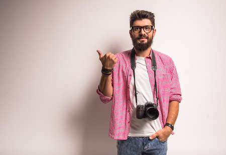 Young cheerful photographer with beard, while working in studioの写真素材