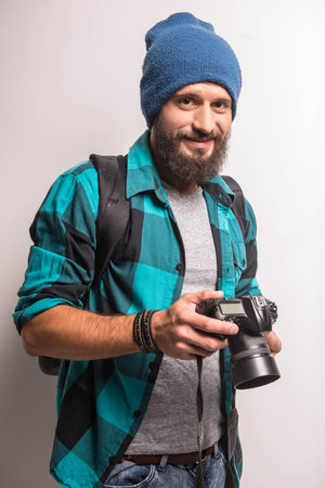 Young cheerful photographer with beard, while working in studioの写真素材