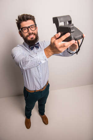 Young cheerful photographer with beard, while working in studioの写真素材