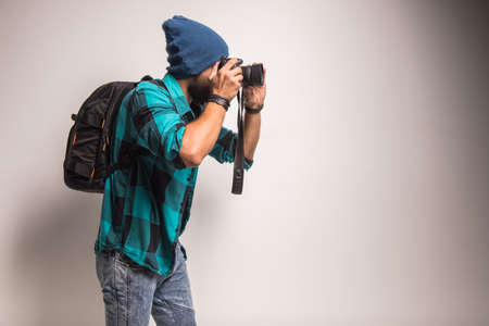 Young cheerful photographer with beard, while working in studioの写真素材