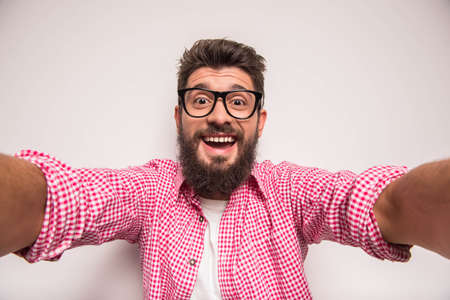Young cheerful photographer with beard, while working in studioの写真素材