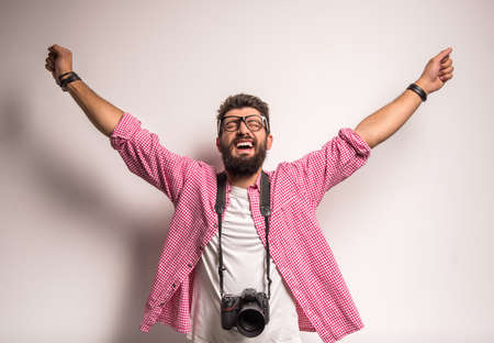 Young cheerful photographer with beard, while working in studioの写真素材