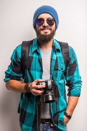 Young cheerful photographer with beard, while working in studioの写真素材