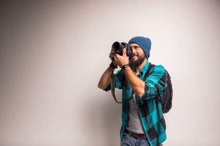 Young cheerful photographer with beard, while working in studioの写真素材