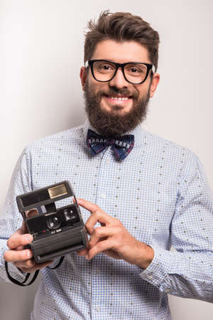 Young cheerful photographer with beard, while working in studioの写真素材