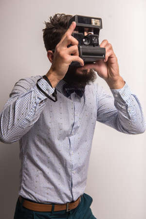 Young cheerful photographer with beard, while working in studioの写真素材