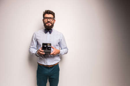 Young cheerful photographer with beard, while working in studioの写真素材