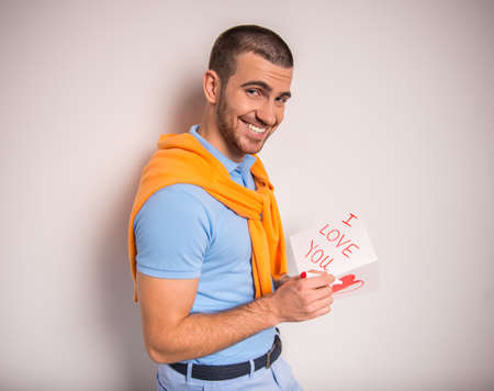 Portrait of a young man with a card for his girlfriendの写真素材