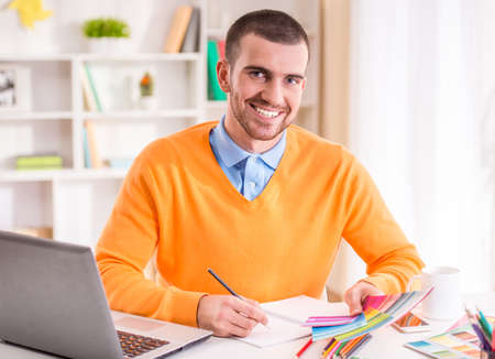 Portrait of a young businessman designer working in officeの写真素材
