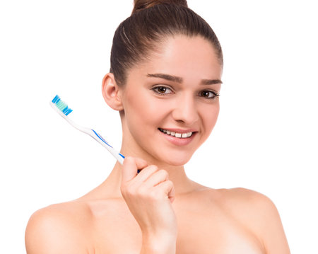 Portrait of a young beautiful woman using toothbrush, isolated on a white background
