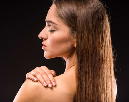 Portrait of a young beautiful woman with long hair, isolated on black backgroundの写真素材