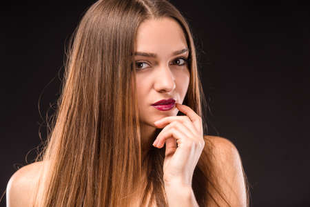 Portrait of a young beautiful woman with long hair, isolated on black backgroundの写真素材