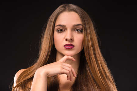 Portrait of a young beautiful woman with long hair, isolated on black backgroundの写真素材