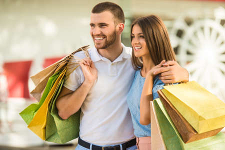 Loving young couple with bags for shopping, walk to townの写真素材