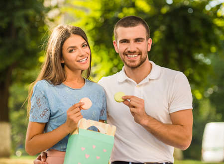 Loving young couple on a date at the park eating sweetsの写真素材