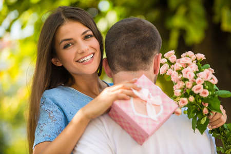 Loving young couple on a date with flowers in the parkの写真素材