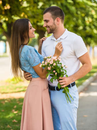 Loving young couple on a date with flowers in the parkの写真素材