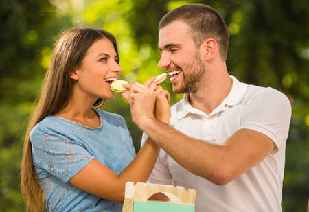 Loving young couple on a date at the park eating sweetsの写真素材