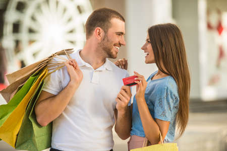 Loving young couple with bags for shopping, walk to townの写真素材