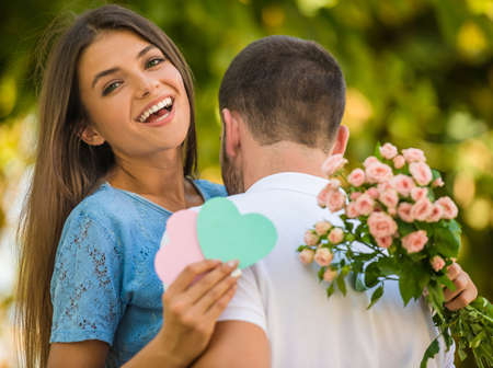 Loving young couple on a date with flowers in the parkの写真素材