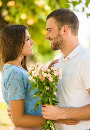 Loving young couple on a date with flowers in the parkの写真素材