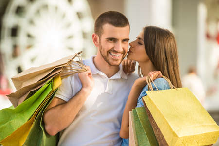 Loving young couple with bags for shopping, walk to townの写真素材