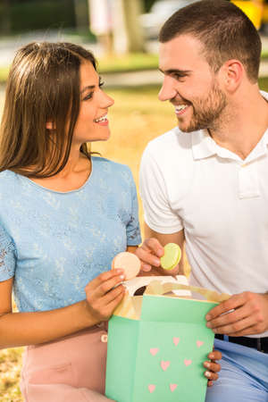 Loving young couple on a date at the park eating sweetsの写真素材