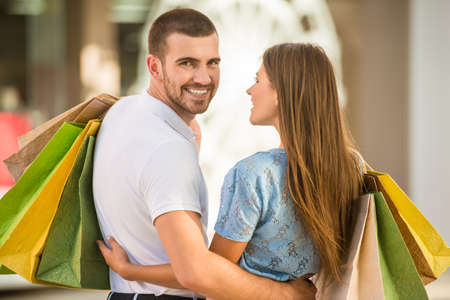 Loving young couple with bags for shopping, walk to townの写真素材