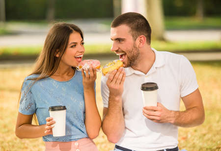 Loving young couple on a date in the park and drink coffeeの写真素材