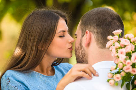 Loving young couple on a date with flowers in the parkの写真素材