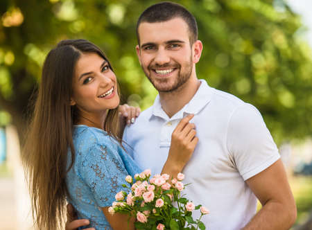 Loving young couple on a date with flowers in the parkの写真素材