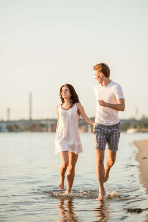 Loving young couple walk on the beach in summerの写真素材