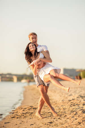 Loving young couple walk on the beach in summerの写真素材