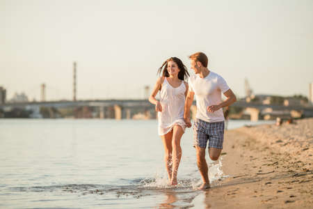 Loving young couple walk on the beach in summerの写真素材