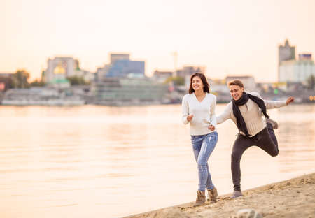 Loving young couple walk on the beach in autumnの写真素材