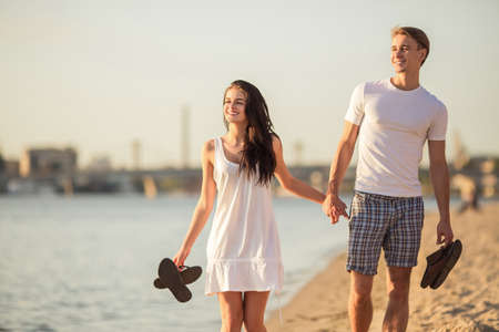 Loving young couple walk on the beach in summerの写真素材