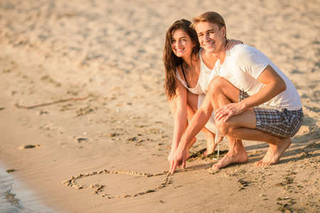 Loving young couple walk on the beach in summerの写真素材