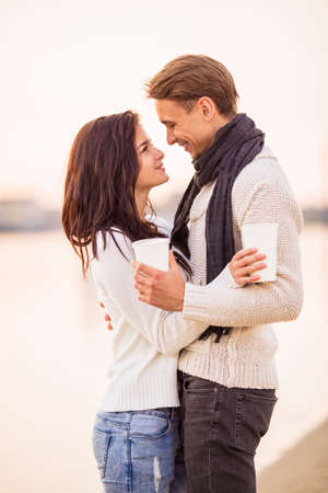 Loving young couple walk on the beach in autumnの写真素材