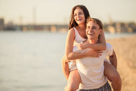 Loving young couple walk on the beach in summerの写真素材