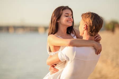 Loving young couple walk on the beach in summerの写真素材
